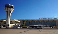 an airport with an air traffic control tower in the background